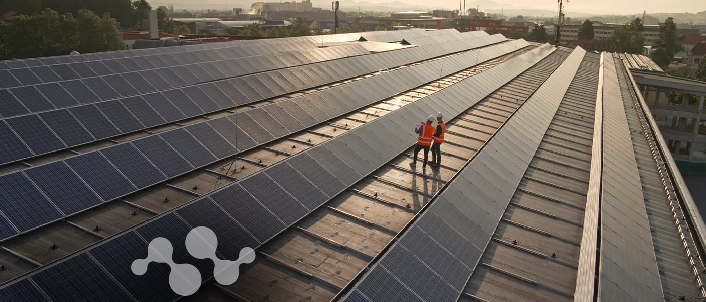 Workers inspecting rooftop solar panel array during utility-scale installation for a solar farm 