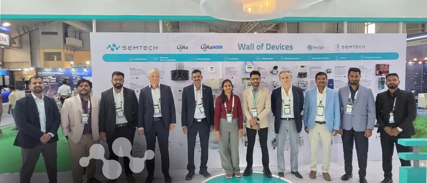 Semtech team at the Electronica India 2026 booth in front of the LoRa Wall of Devices display